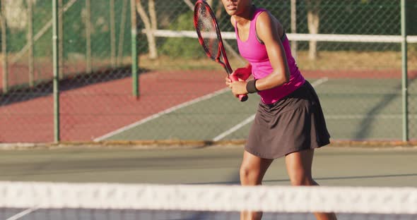 Video of focused african american female tennis player holding racket and hitting ball