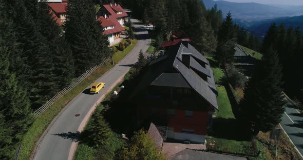 Drone View of Yellow Car That Drives Into the Austrian Alps Mountains Village