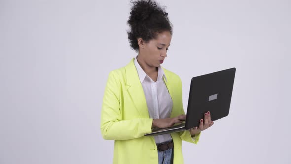 Happy Young Beautiful African Businesswoman Thinking While Using Laptop