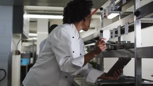 African american female chef taking orders in restaurant kitchen