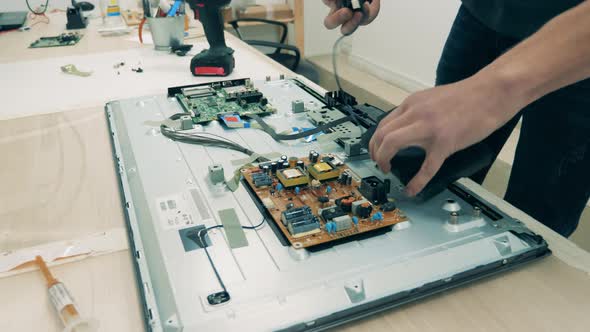 Male Engineer Is Dismantling an Electronic Device