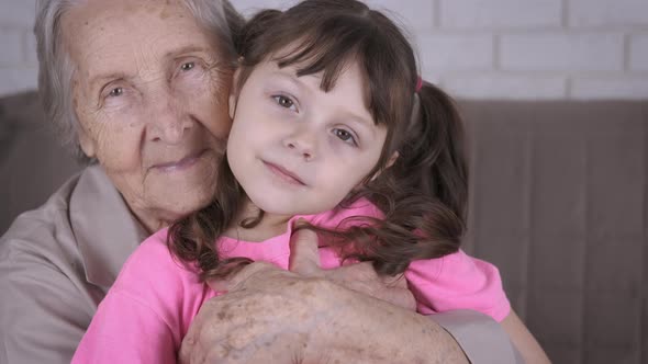 An older woman is hugging a child