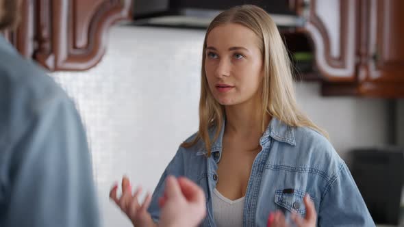 Portrait of Dissatisfied Angry Young Beautiful Woman Talking with Man in Kitchen at Home