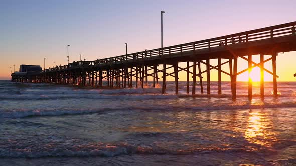 People walking on the Newport Beach pier during sunset