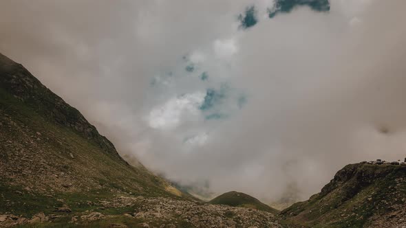 Timelapse with rising clouds between mountains