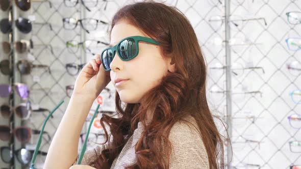 Little Girl Trying on Sunglasses at the Eyewear Store