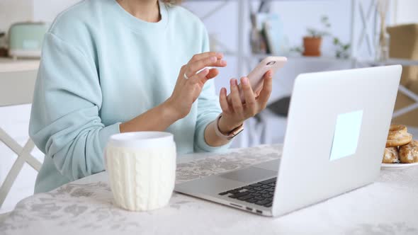 Woman Using Smartphone And Laptop. Workspace At Home For E-Learning And Remote Work.