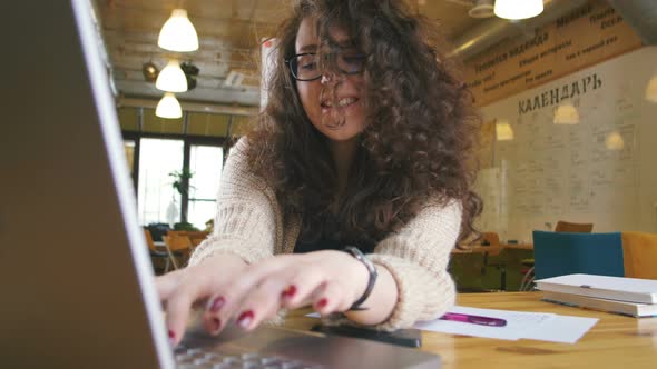 Young Happy Woman Working in the Office Writing Something and Using Computer