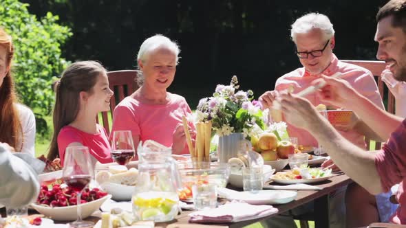 Happy Family Having Dinner Party at Summer Garden 