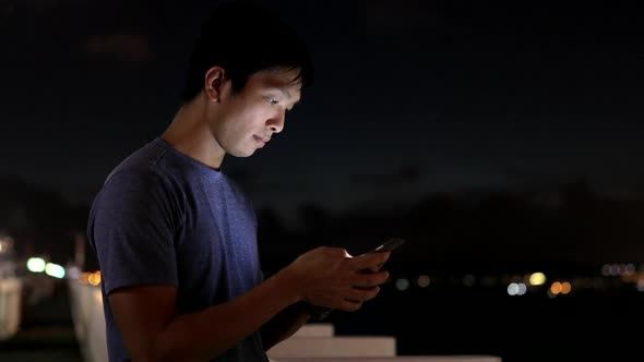 Man use of mobile phone in Hong Kong at night 