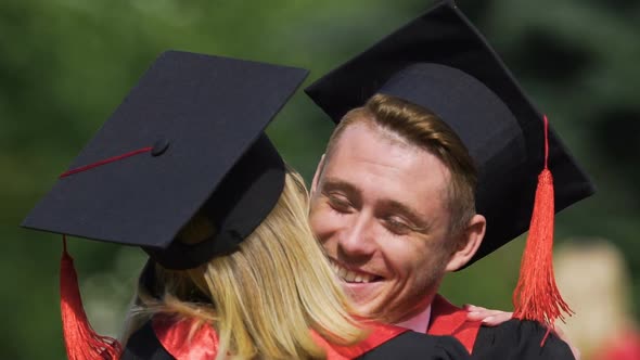 Couple of Beautiful Graduates Smiling and Hugging, Enjoying Moment, Emotions