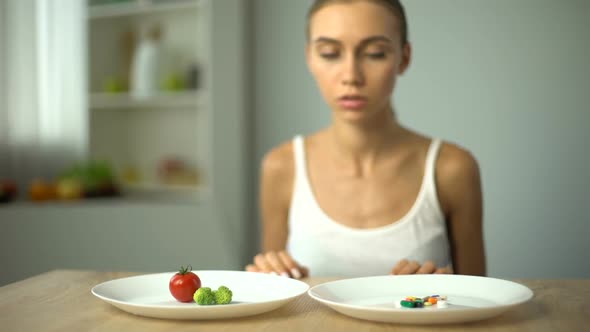 Anorexic Girl Choosing Weight Loss Drugs Instead of Vegetables, Unhealthy Diet