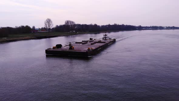 Aerial View Around Forward Bow Of Barge With Fork Lift On It Being Transported By Push Boat On Oude