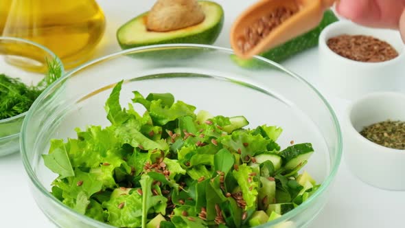 Woman Cooking Salad of Fresh Green Vegetables and Herbs