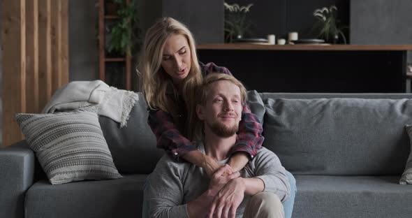 Couple Enjoying Honeymoon Together Resting on Comfortable Couch at Luxury Apartment