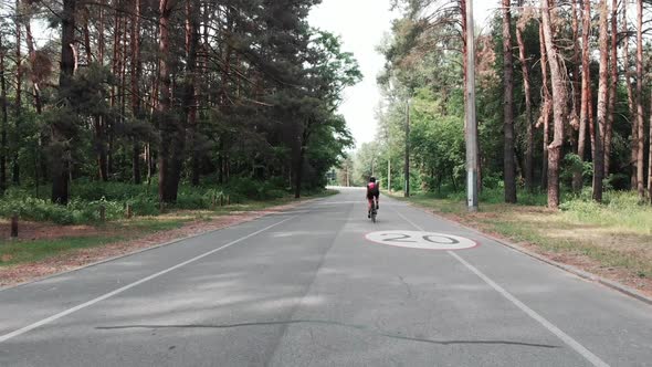 Young Attractive Triathlete Woman Is Training on A Bicycle in The Forest