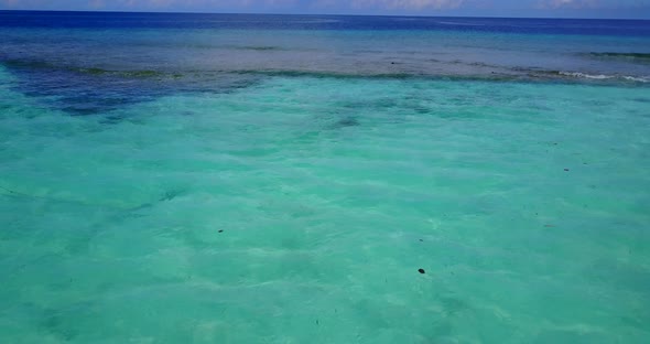 Tropical drone tourism shot of a white paradise beach and blue sea background in vibrant 4K