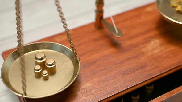 Balancing vintage scales with miniature weights and gold nuggets on brass dishes