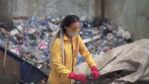 Womanvolunteer in Yellow and Transparent Protecting Glasses Sorting Used Plastic Bottles at Modern