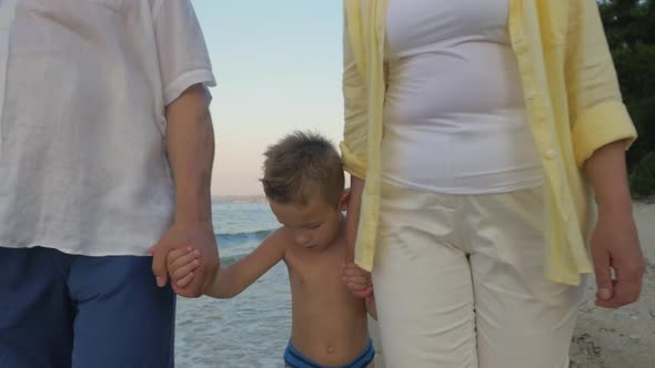 Child with grandparents walking on the shore