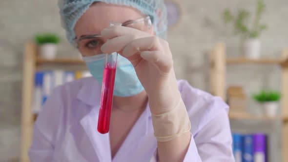 Close Up of a Woman Laboratory Assistant Conducting a Study of Fluid in a Test Tube Slow Mo