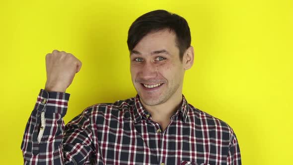 A Funny, Handsome Guy Says Yes and Makes a Hand Gesture Expressing Victory. Portrait of a Young Guy