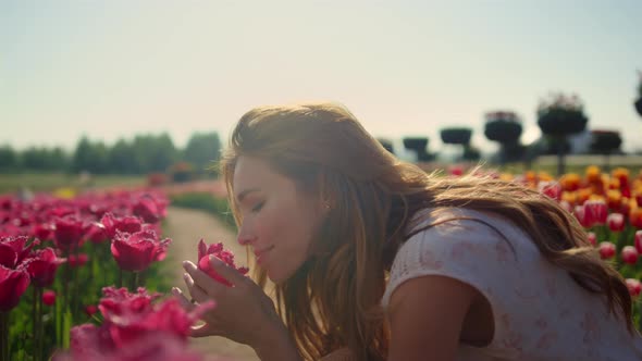 Emotional Girl Smelling Flowers in Sunset Light