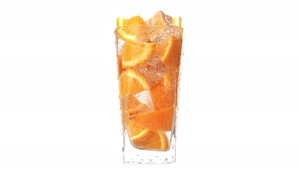 Fresh Summer Rotation Glass Cocktail with Orange Piece Ice and Bubbles Mineral Water Slowmo Isolated