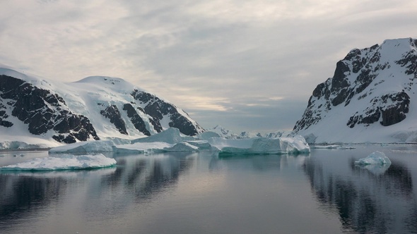 Environment. Reflection of mountains and icebergs in the water. Antarctica. Life of nature.