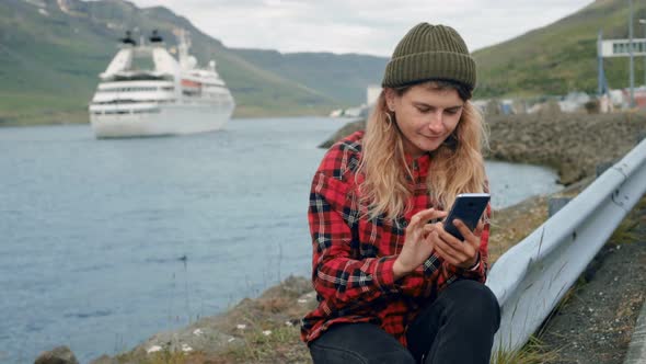 Young Woman Sits in Port Watch Cruise Ship Leave