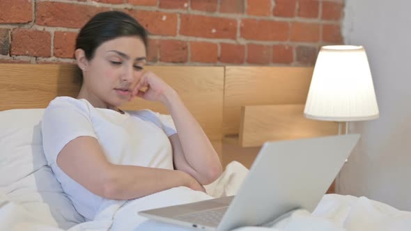 Young Indian Woman with Laptop Sleeping in Bed