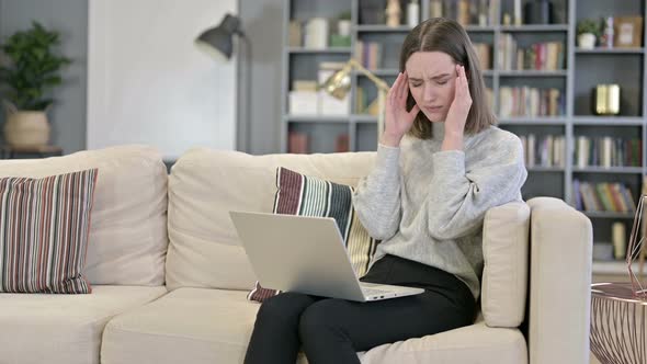 Young Woman Working on Laptop and Having Headache in Office