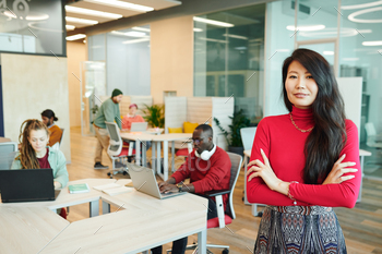 Young smiling businesswoman of Asian ethnicity crossing her arms by chest / Photodune, Misc
