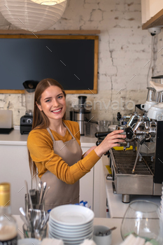 Smiling barista using professional equipment for her work / Photodune, Misc