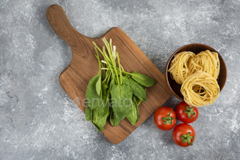 Wooden board with fresh vegetables and raw noodles on marble surface / Photodune, Misc