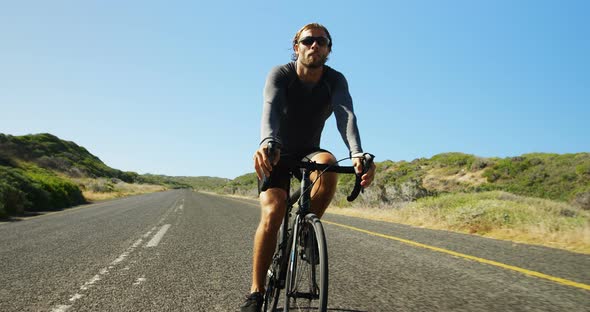 Triathlete man cycling in the countryside road