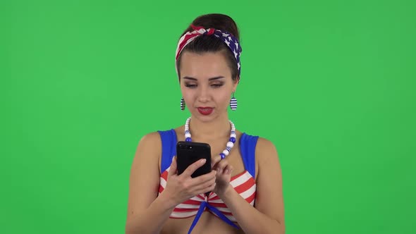 Portrait of Beautiful Girl in a Swimsuit Is Talking for Mobile Phone and Rejoicing . Green Screen