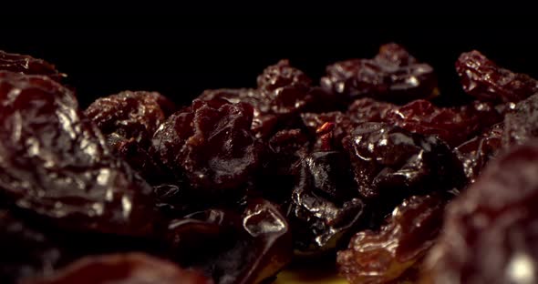 A Dry Grapes Macro Shot Closeup Shot of Ripe Raisins Lies on a Table Against a Black Background