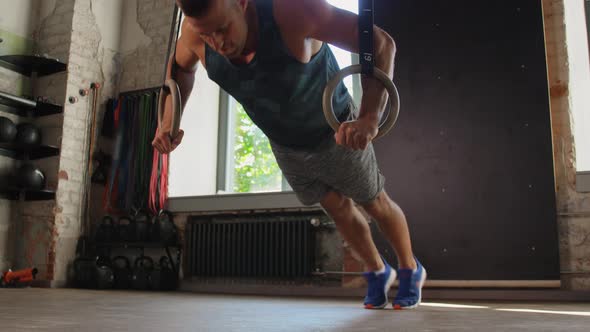 Man Doing Push-ups on Gymnastic Rings in Gym