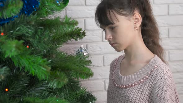 Teen by winter tree with decorations. 