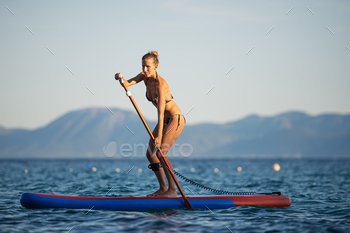 Fit young woman paddling on sup board / Photodune, Misc