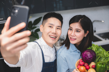 husband and wife are smile together with mobile phone, mature indoor photo with girlfriend / Photodune, Misc