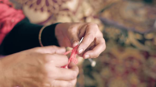 Woman's hands knit with red wool and needle crafts. Close up 4k of knit work tie-up hand work