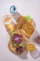 Hamburger with sliced pastrami served with lettuce on a freshly baked sesame bun over white - PhotoDune Item for Sale