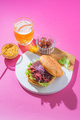 Pastrami burger with mustard, beer and pickels over bright pink background - PhotoDune Item for Sale
