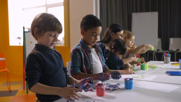 Diverse Children Hand Painting in Kindergarten