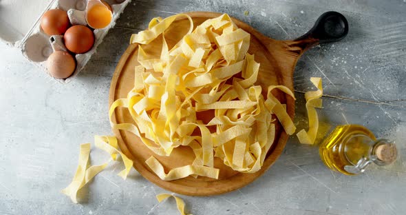 Dry Fettuccine Pasta on a Cutting Board Rotates Slowly.