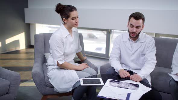 Male Dentist Discussing Jaw X-Ray with Colleagues