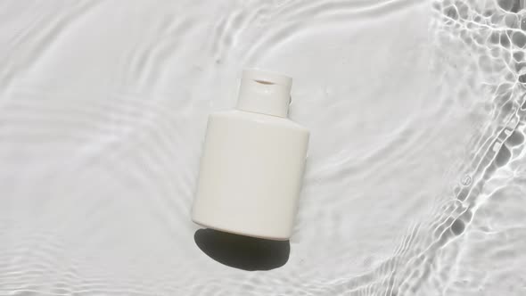 Cosmetic Cream Bottle of Lotion Serum Micellar Toner and Emulsion on Water Background with Splashes