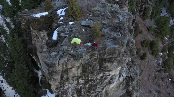 Aerial view of rocky cliff with campsite on top